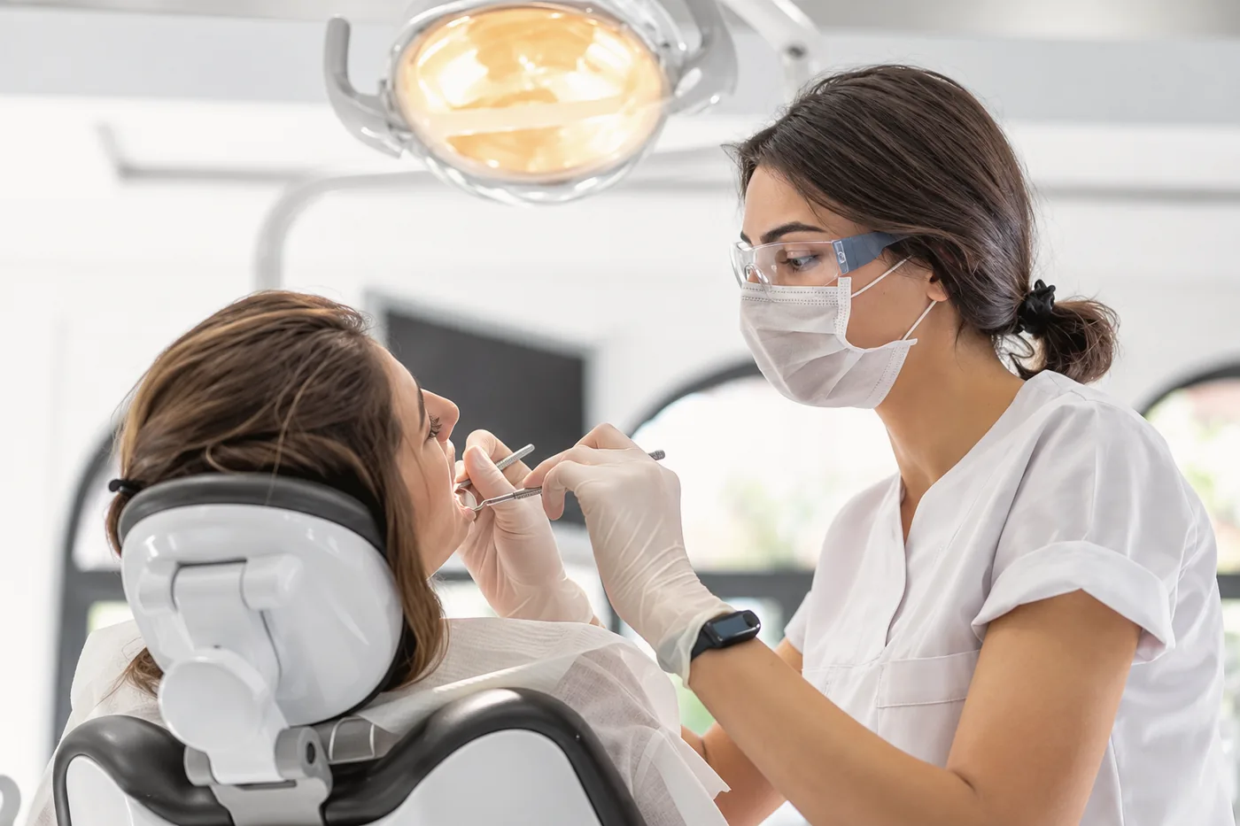 A dentist examining a patient under the treatment light